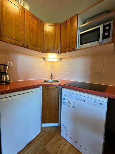 La cuisine est équipée d'un réfrigérateur blanc et d'un four micro-ondes. dans l'établissement T3 6 personnes pied des piste, balcon 2 chambre separe a la semaine samedi au samedi, aux Orres