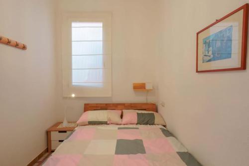 Un dormitorio pequeño con una cama y una ventana. en Casa sul lungomare, en S'Archittu