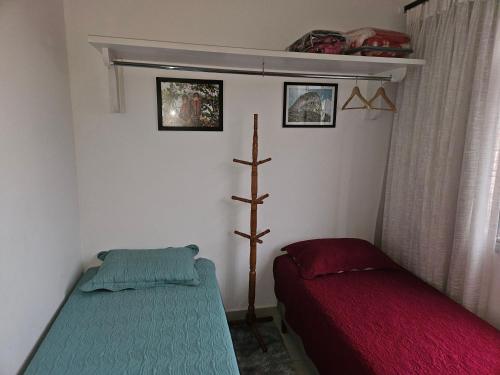 a bedroom with two beds and a cross at casa duplex sergio e claudia in Vitória
