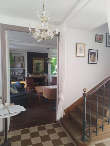 a living room and dining room with a chandelier at Il était une fois un jardin in Saint-Fargeau