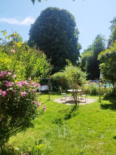 a garden with a table and chairs and flowers at Il était une fois un jardin in Saint-Fargeau