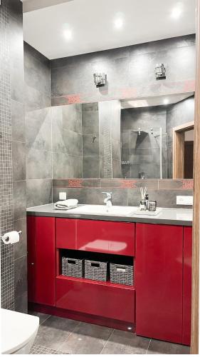 a bathroom with red cabinets and a red sink at Stella Di Mare in Zakopane
