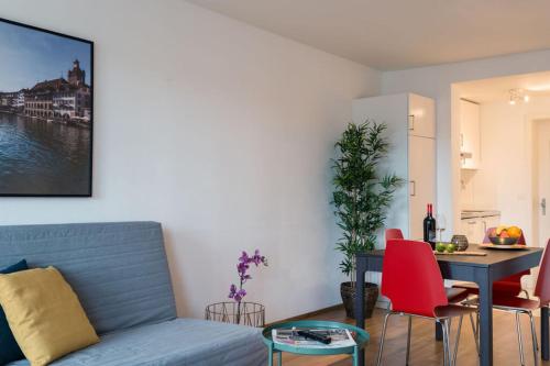 a living room with a blue couch and a table at HITrental Chapel Bridge Apartments in Luzern