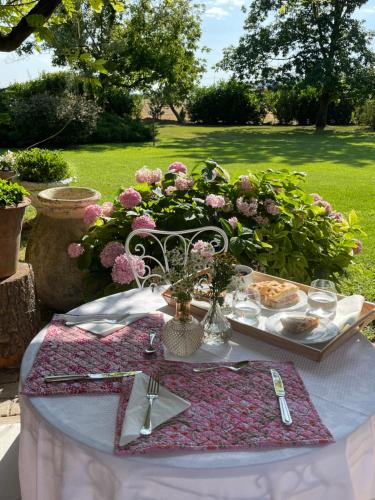a table with a plate of food and flowers on it at Tenuta Pizzone Wine Resort in Rivanazzano