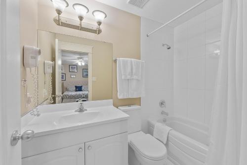 a white bathroom with a sink and a toilet at Lakeshore Inn in Cold Lake