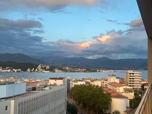une ville avec vue sur l'eau et les bâtiments dans l'établissement Très bel appartement avec terrasse de 87m2 avec une superbe vue panoramique sur la baie d Ajaccio, à Ajaccio