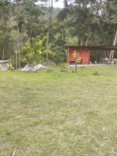 a cabin in a field of grass with trees at Refugio los naranjales in Las Mesitas