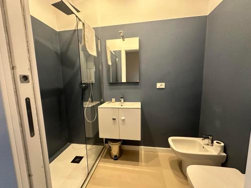 a bathroom with a sink and a toilet and a mirror at Sunset Guest House in Reggio Calabria
