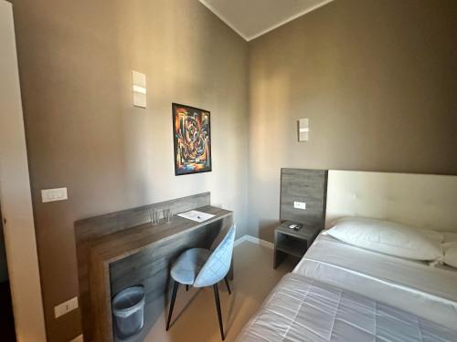 a small room with a bed and a desk and a bed sidx sidx sidx sidx at Sunset Guest House in Reggio Calabria
