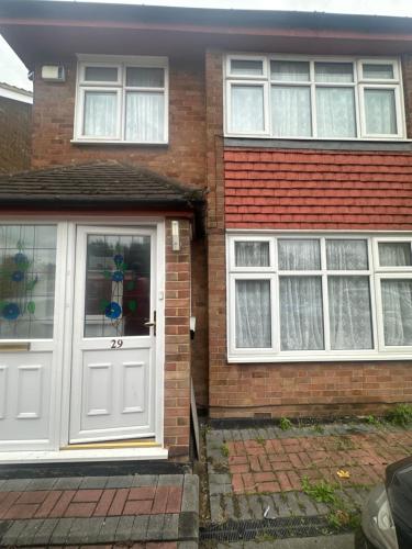 a brick house with a white door and windows at Grand House in Dagenham