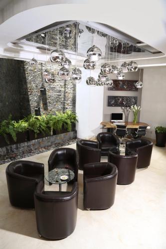 a restaurant with black chairs and tables and plants at Ejecutivo Express Guadalajara Providencia - Av México in Guadalajara