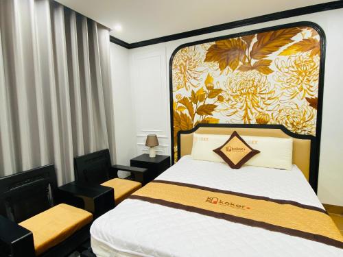 a hotel room with a bed and two chairs at KOKORO HOTEl & HOMESTAY in Cao Bằng