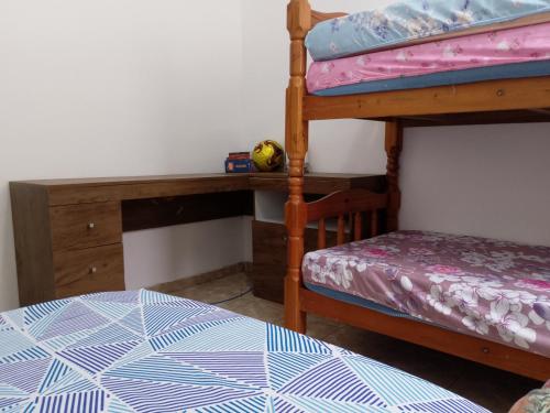 a bedroom with a bunk bed and a desk at Apto Domeni, seu conforto a 10 min da praia! in Praia Grande