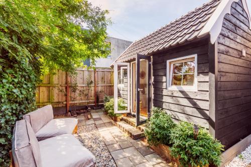 a tiny house with a patio and a fence at Tiny house Zaandam in Zaandam