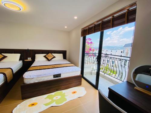 a bedroom with two beds and a view of a balcony at KOKORO HOTEl & HOMESTAY in Cao Bằng