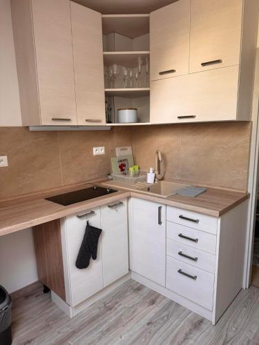 a kitchen with white cabinets and a sink at Apartman RUŽA7 in Ružomberok