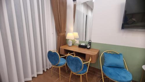 a room with two blue chairs and a table at KOKORO HOTEl & HOMESTAY in Cao Bằng
