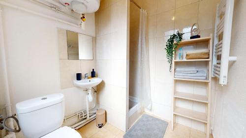 une salle de bain blanche avec des toilettes et un lavabo dans l'établissement Le Studio Platine, à Mulhouse