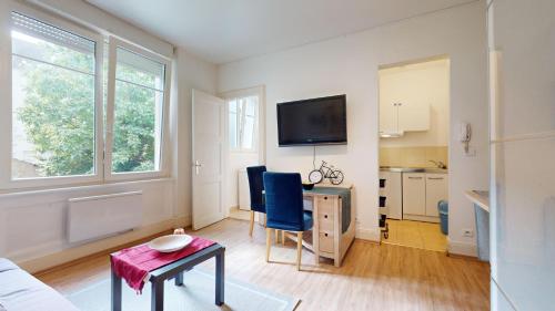un salon avec une table et des chaises bleues dans l'établissement Le Studio Platine, à Mulhouse