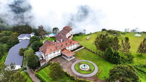an aerial view of a large house on a hill at Le Montfort Resort in Munnar
