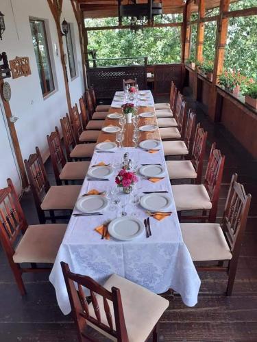 a long table with chairs and plates on it at Casa Boiereasca in Iaşi