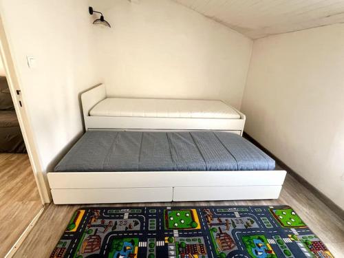 - un lit dans une petite chambre avec un tapis dans l'établissement Charmante maison climatisée 6 personnes proximité plage, à Frontignan