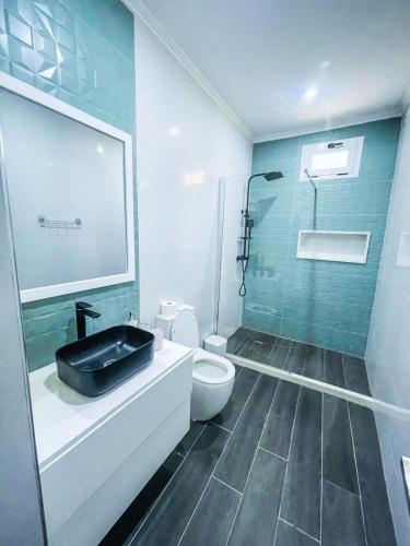a bathroom with a sink and a toilet and a shower at Résidence Cazino Apartamentos in Praia