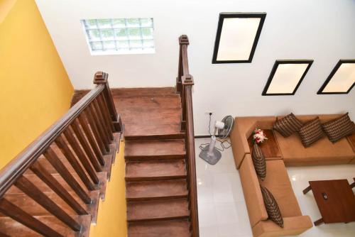 a spiral staircase in a home with yellow and white walls at Travel Neth Holidays Bungalow Anuradhapuraya in Anuradhapura