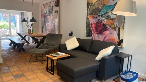 un soggiorno con un divano e un tavolo di Großes Grachtenhaus - Simmerdeis an der Gracht a Friedrichstadt
