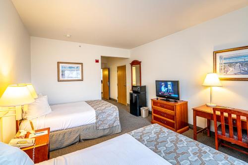 una camera d'albergo con due letti e una televisione di Anchorage Motel Inc. a Rehoboth Beach