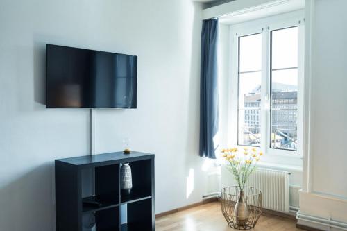 a living room with a flat screen tv on a wall at HITrental Chapel Bridge Apartments in Luzern