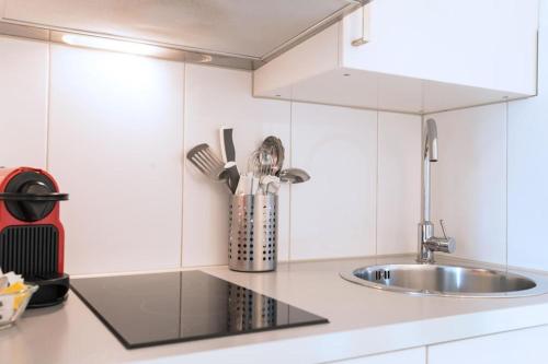 a kitchen with white cabinets and a sink at HITrental Chapel Bridge Apartments in Luzern