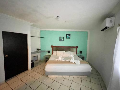 a bedroom with a bed and a blue wall at Chi Ibal Hu Cancun in Cancún