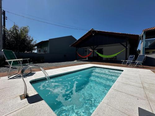 una piscina con un'altalena e un piscinettatore di BS01- Casa com Piscina Aquecida e Churrasqueira a Balneário Barra do Sul