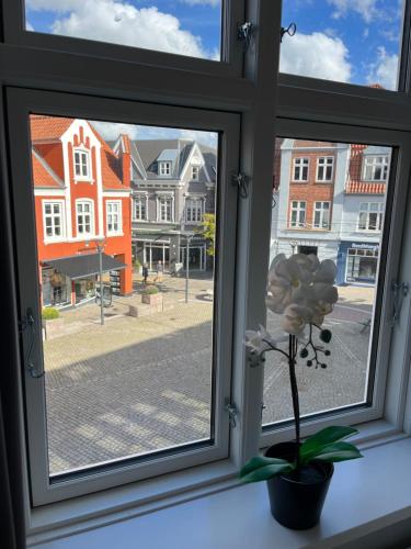 a window with a view of a street and buildings at Niollo Hotel & Apartments in Aabenraa