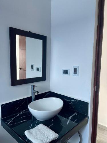 a bathroom with a sink and a mirror on a counter at Excelente Departamento en planta baja colonia Altabrisa in Mérida