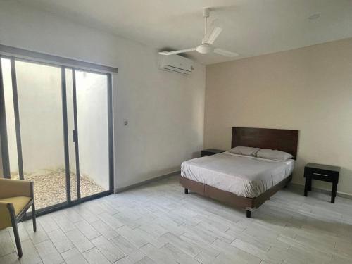 a bedroom with a bed and a ceiling fan at Excelente Departamento en planta baja colonia Altabrisa in Mérida