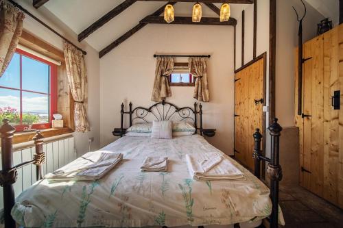 una camera da letto con un letto grande con asciugamani sopra di Geraghtys Farmyard Pods a Mayo