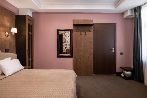 a hotel room with a bed and a door at Shato Luxe in Odesa