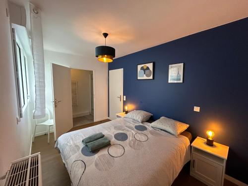 une chambre avec un grand lit aux murs bleus dans l'établissement Le Repaire de Mickey, à Chessy