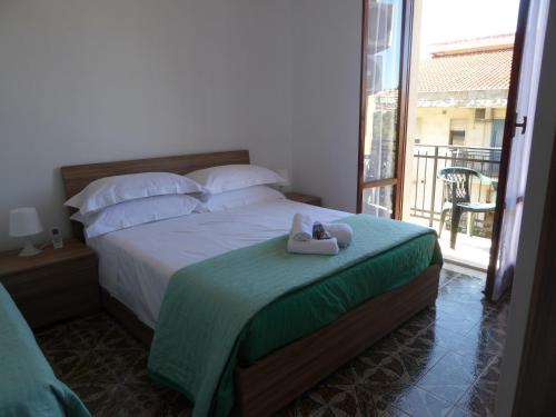 a bedroom with a bed with two stuffed animals on it at The Shamrock House in Palazzolo Acreide