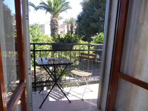 a balcony with a table and chairs and a palm tree at The Shamrock House in Palazzolo Acreide