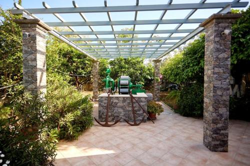a patio with a pergola with a green machine at Luxury 3 Bedroom Apartment with Garden in Chios