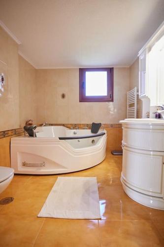 a large bathroom with a tub and a sink at Luxury 3 Bedroom Apartment with Garden in Chios