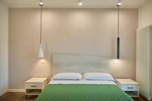 a bedroom with a large bed with a green blanket at MiRa Assisi - Rubino in Bastia Umbra