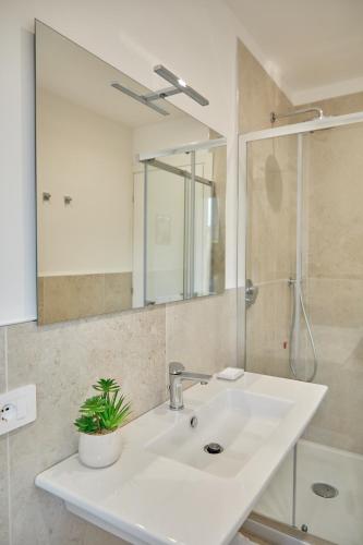 a bathroom with a white sink and a mirror at MiRa Assisi - Rubino in Bastia Umbra