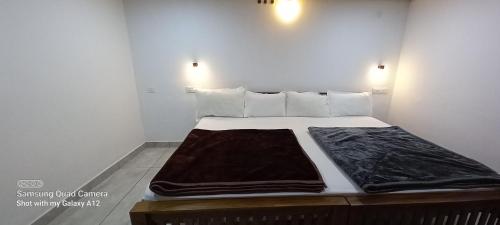 a bed in a white room with at Perumaal Homestay in Munnar