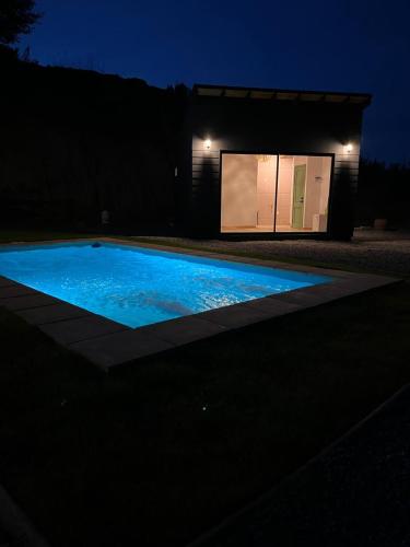 a swimming pool in front of a building at night at Grado8punto8 Glamping Valle de Los Artistas in Lolol