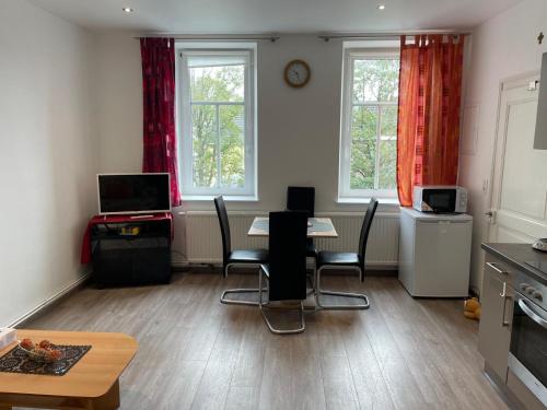 a kitchen with a table and chairs and two windows at PlanetOase Eupen in Eupen