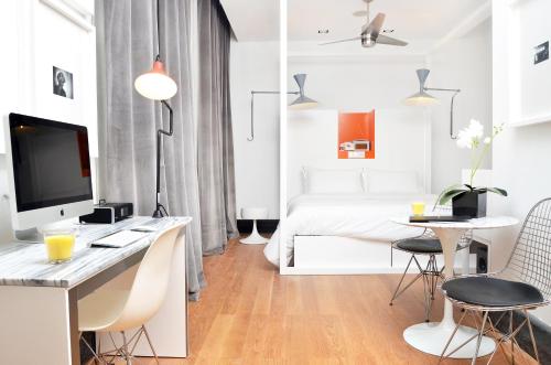 a white room with a desk with a computer and a bed at Browns Boutique Hotel in Lisbon